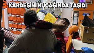 Dumandan etkilenen kardeşini kucağında taşıdı