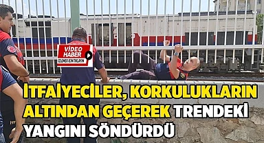 İtfaiyeciler korkulukların altından geçerek trendeki yangını söndürdü