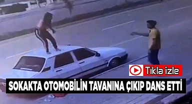 Sokakta otomobilin tavanına çıkıp dans etti